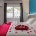 Mar Hotel, Balneário Camboriú room with bed covered in rose petals and a window view of palm trees