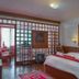 Hotel Tashi Delek in Gangtok guest room with two beds, red accents, and a decorative wall hanging