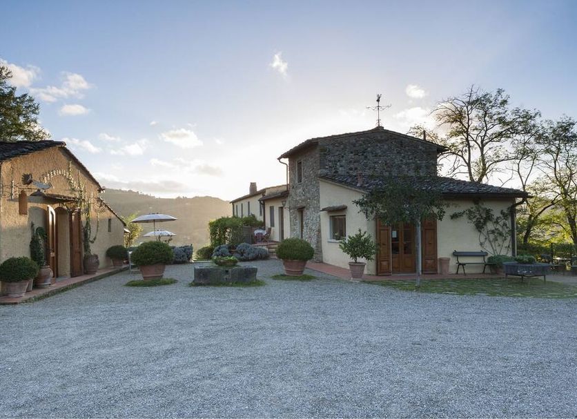 Relais Poggio Borgoni in San Casciano Val Di Pesa, rural courtyard with stone buildings and sunset view