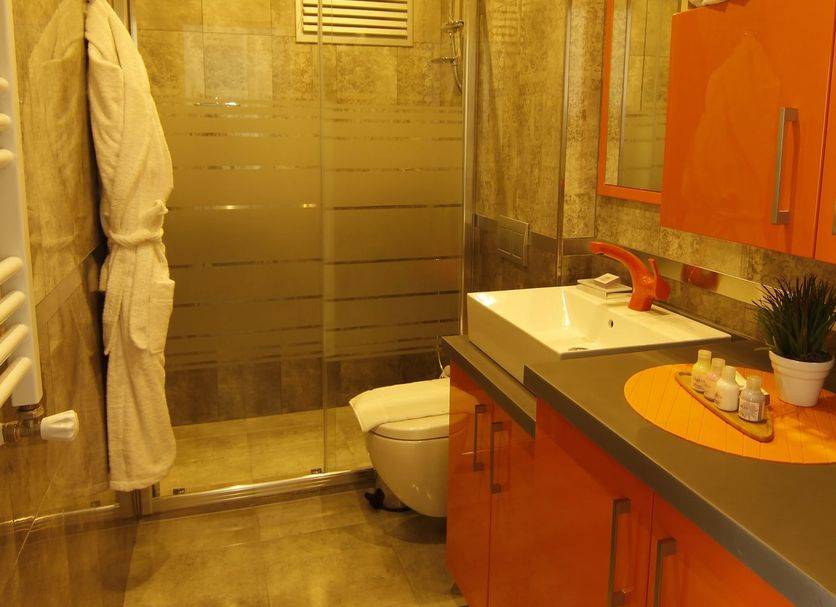 Zin D Home Cekmekoy Istanbul bathroom with walk-in shower, orange vanity, and toilet