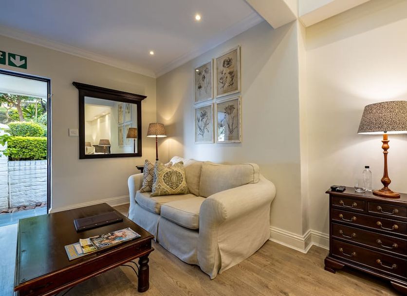 Sheppard Boutique Hotel in Nelspruit living room with sofa, coffee table, lamp and framed wall art