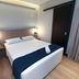 Hotel Arco Do Sol room in Balneário Camboriú with double bed, bedside lamps, and curtain-covered window
