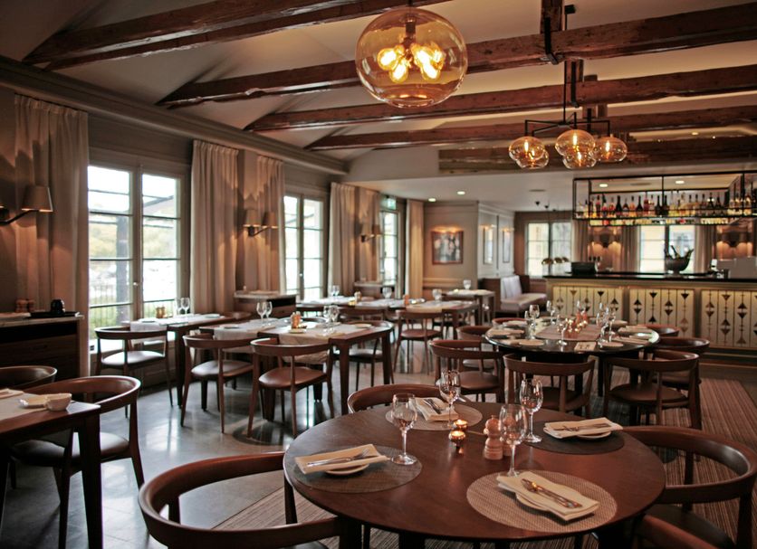 Stallmästaregården Hotel, Stockholm dining room with round tables, wood beams, and bar seating