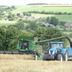 Manor Farm B&B in Marlborough overlooking rolling countryside with a tractor and combine harvesting a field