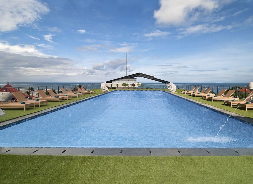 Sulis Beach Hotel & Spa Kuta oceanfront infinity pool with sun loungers and sea view