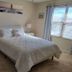 Happy Valley House Phoenix guest room with queen bed, armchair, nightstand and window blinds