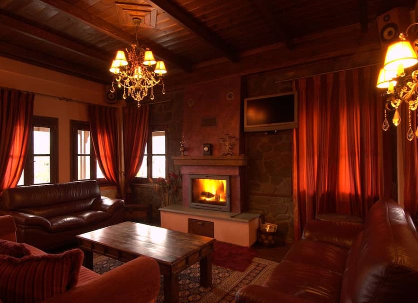 Hotel Kroupi in Elati lounge with leather sofas, fireplace and chandelier lighting