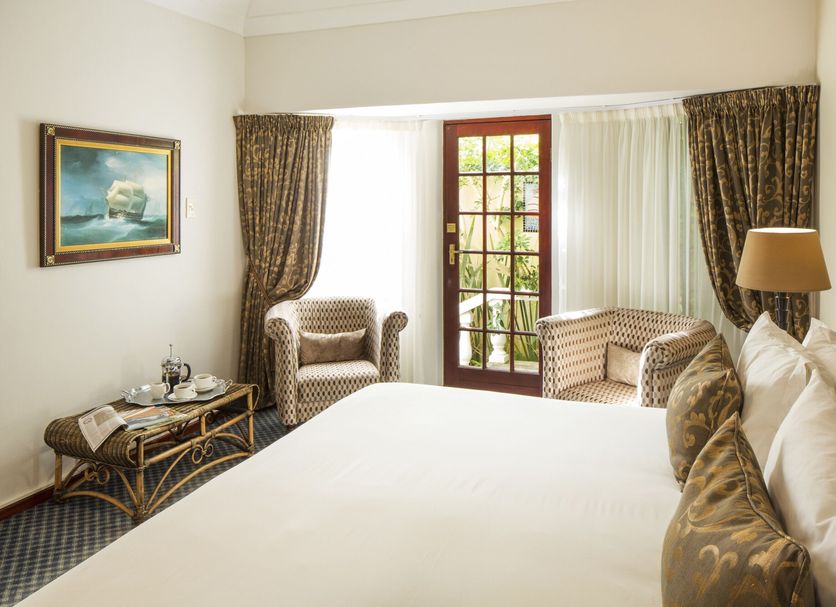 Kingfisher Guesthouse in Port Elizabeth room with king bed, armchairs, French doors and garden view