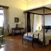 Ananda in the Himalayas room in Rishikesh with a four-poster bed, wood floors, and bedside lamps