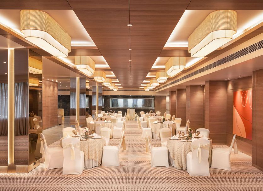 Mercure Chandigarh Tribune Chowk banquet hall in Chandigarh with round dining tables and chairs