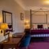 The Bedford Hotel, Tavistock: guest room with four-poster bed, desk, armchair and lamps