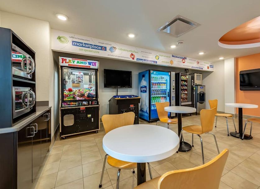 Motel 6 Mankato shows a guest lounge with arcade machine, vending machines, tables and chairs