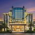 Dongguan Huaxi International Hotel exterior at dusk with illuminated entrance and palm trees in Dongguan