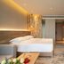 Expo Garden Resort Hotel Jinan room with king bed, desk, wall-mounted TV and warm lighting
