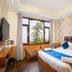 Hotel Woodrina in Shimla guest room with king bed, window seating, and mountain-view window