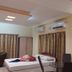 Hotel Sea Coast in Digha guest room with twin beds, curtains, air conditioning, and a glass table