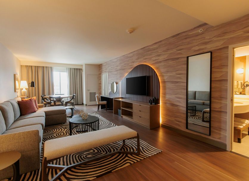 Hilton Garden Inn Sioux Falls Downtown suite with seating area, TV wall, and city view