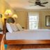 The Stella Rose B&b in Wolfville: cozy bedroom with queen bed, wood floors, ceiling fan, and window.
