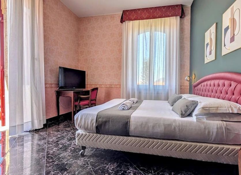 Villa Fieschi Boutique Hotel, Lavagna: bright guest room with pink tufted bed, desk, TV, and window