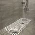 The Frocester Stroud bathroom shower with gray tile walls and mosaic shower floor