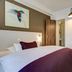 Hotel West Hamburg guest room with bed, wood doors, wall art and hanging lamp