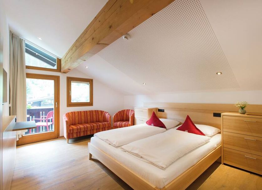 Familienhotel Mateera Gargellen room with twin bed, sofa nook and mountain-view balcony