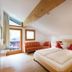 Familienhotel Mateera Gargellen room with twin bed, sofa nook and mountain-view balcony