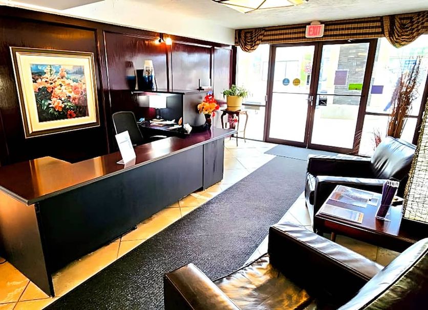The Medicine Hat Villa lobby with front desk, seating area, and glass entrance in Medicine Hat