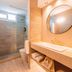 Atlántico Boutique Hotel in Punta del Este bathroom with walk-in shower, vanity, and round mirror
