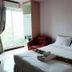 The Loom Rangsit room with bed, red chair and window view in Pathum Thani
