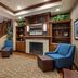 Comfort Inn & Suites Virginia Beach - Norfolk Airport lobby with fireplace, staircase, and blue chairs