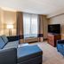 Comfort Inn & Suites Virginia Beach - Norfolk Airport guest room with sofa, armchair, TV, and window