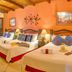 Hotel Casa del Parque in Antigua: colorful triple room with wooden-beam ceiling and three beds