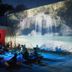 Radio Tulum in Tulum: outdoor nighttime lounge with guests seated before waterfall projection