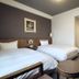 Hotel Route-Inn Iwakiizumi Ekimae guest room with two twin beds and entry door in Iwaki