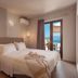 Porto Kaza in Sitia bedroom with king bed, pendant lights and balcony sea view