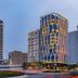 Stella Maris Beach Danang high-rise hotel at dusk in Da Nang with illuminated facade and city traffic