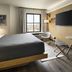 Moxy Memphis Downtown guest room with king bed, wall-mounted TV, and city-view window in Memphis