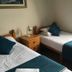 The Kings Arms London twin room with two single beds, teal bedding, and a window with curtains