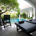 Palm Grove Resort in Pattaya with shaded poolside lounge chairs beside an outdoor pool and white arches