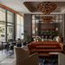 The Tess, Autograph Collection Atlanta lobby lounge with chandeliers, leather sofa, and bar seating