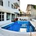 Erato Hotel in Agia Marina with a small outdoor pool and sun loungers beside a white hotel building.