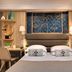 Serotel Suites Paris guest room with twin beds, desk, and decorative wall art