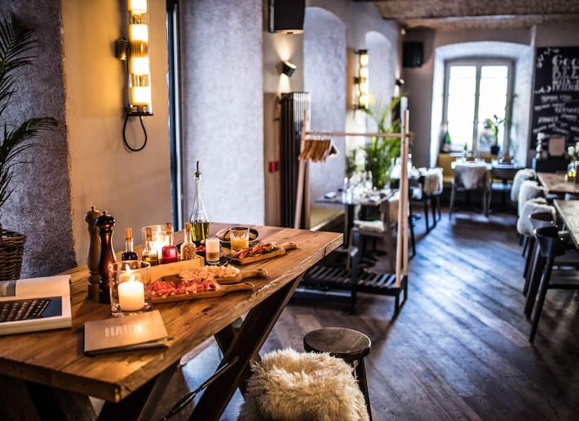 Vander Urbani Resort Ljubljana dining area with rustic table, candles, and wood floors