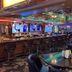 Prospector Hotel & Gambling Hall in Ely casino bar with stools, tables and neon-lit ceiling