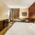 Red Roof Plus Long Island - Garden City room in Westbury with king bed, desk, TV, and window seating