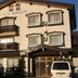 Villa Katashio in Nozawa Onsen, exterior of a small lodge with balconies and parked vans