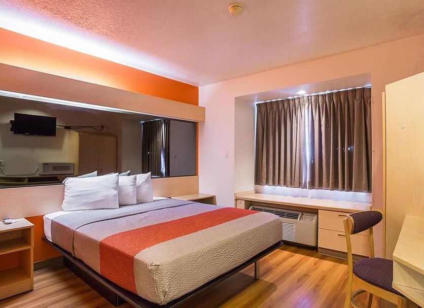 Motel 6 Bernalillo guest room with bed, window bench, and wood-look flooring