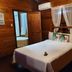Hacienda el Jibarito in San Sebastián room with wood-paneled walls, bed, and window air conditioner