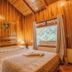 Cabañas La Pradera Monteverde wooden cabin bedroom with king bed and window view